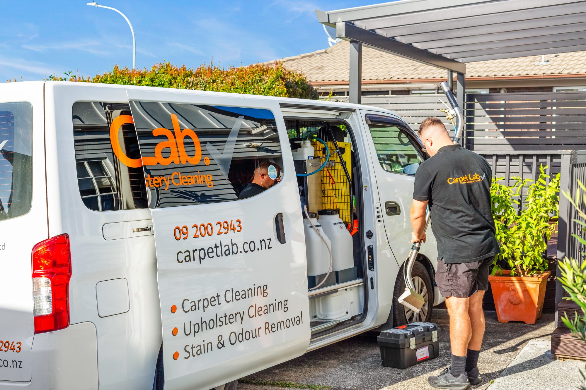 Carpet Lab technician unloading professional cleaning equipment from the branded service van