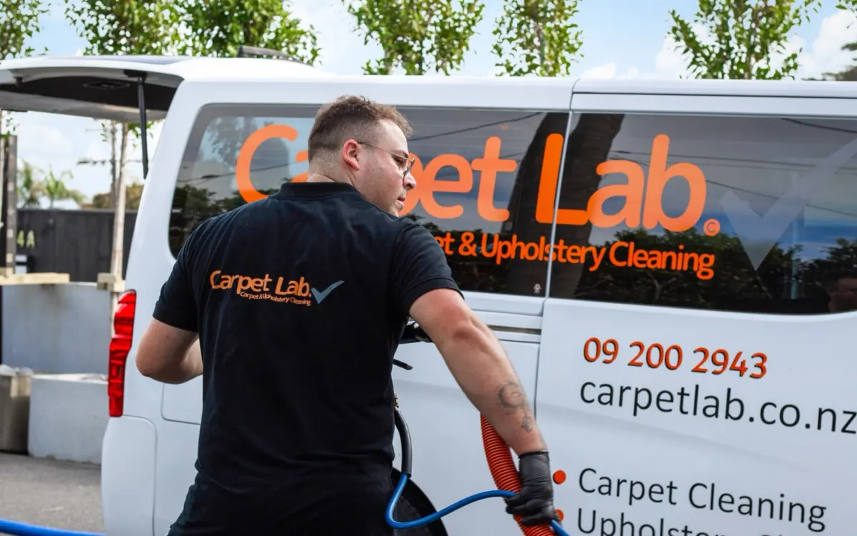 Carpet Lab technician preparing cleaning hoses beside the branded service van