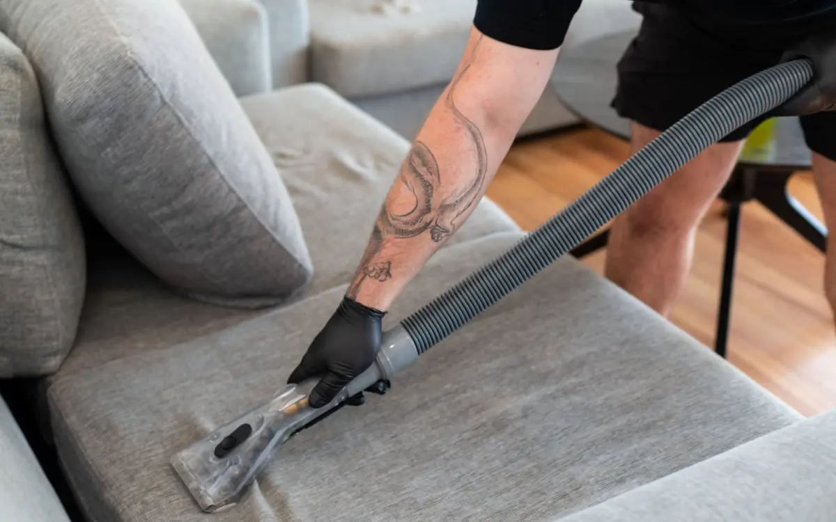 Carpet Lab technician using an upholstery extraction tool on a sofa